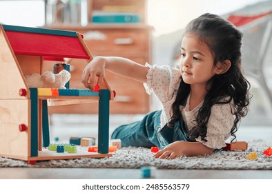 Girl, dollhouse and child play on floor, games and fantasy for brain development in home. Female person, toys and blocks on ground for entertainment, growth and toddler for education or learning - Powered by Shutterstock