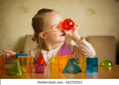 Girl with Down syndrome playing with geometrical shapes - Shutterstock ID 422723515
