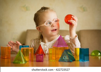 Girl with Down syndrome playing with geometrical shapes - Shutterstock ID 422723527