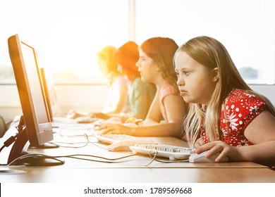 Girl with Down syndrome using computer at school - Shutterstock ID 1789569668