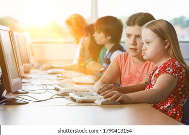 Girl with Down syndrome using computer at school