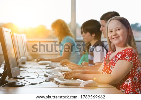 Girl with Down syndrome using computer at school