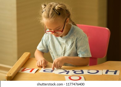 A Girl With Down's Syndrome Is Studying The Alphabet