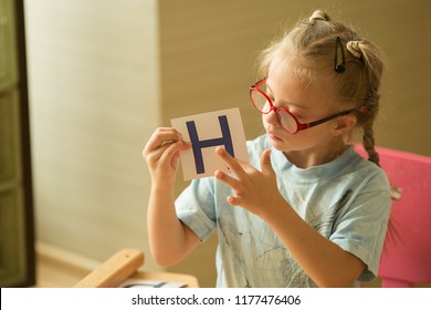 A Girl With Down's Syndrome Is Studying The Alphabet