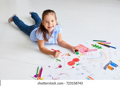 Girl Drawing On A Large Sheet Of White Paper