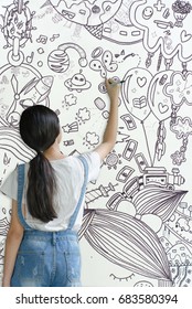 girl drawing picture on wall about her mind, imagination, dream and hope in life 