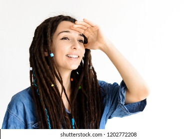 Girl With Dreadlocks Looking Into The Distance Shielding Her Eyes With Her Hand From The Light. Peep Change. Girl Smiling To Someone Away