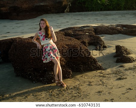 the girl in the dress around the rocks at the beach