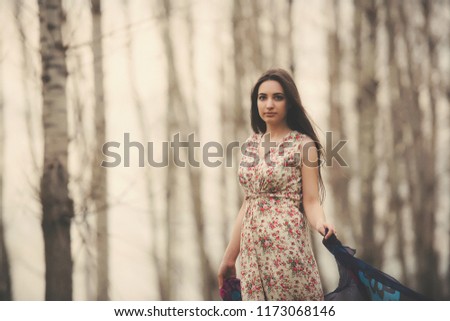Girl in a dress in autumn forest. Photoshoot of a Russian girl in nature. Lonely woman in cloudy weather