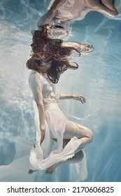            A girl in a dress with lace swims underwater as if in zero gravity                    