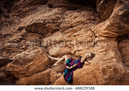The girl in a dress on a rock