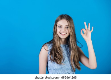 Girl in dress. Woman with long hair and makeup. Beauty and fashion. Fashion model on blue background. Youth and skincare. - Shutterstock ID 695664268