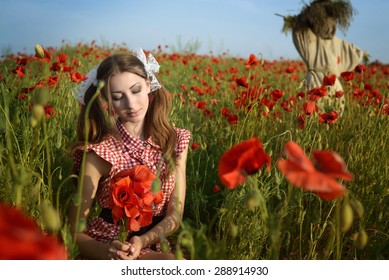Girl dressed up as Dorothy from Oz. poppy field. With scarecrow