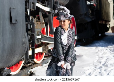 Girl Dressed As A Noblewoman Of The 19th Century Near A Steam Locomotive