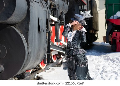 Girl Dressed As A Noblewoman Of The 19th Century Near A Steam Locomotive