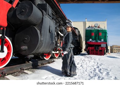 Girl Dressed As A Noblewoman Of The 19th Century Near A Steam Locomotive