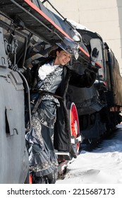 Girl Dressed As A Noblewoman Of The 19th Century Near A Steam Locomotive