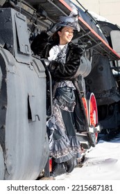 Girl Dressed As A Noblewoman Of The 19th Century Near A Steam Locomotive