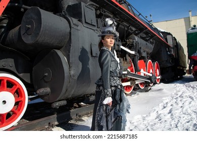 Girl Dressed As A Noblewoman Of The 19th Century Near A Steam Locomotive