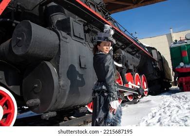 Girl Dressed As A Noblewoman Of The 19th Century Near A Steam Locomotive