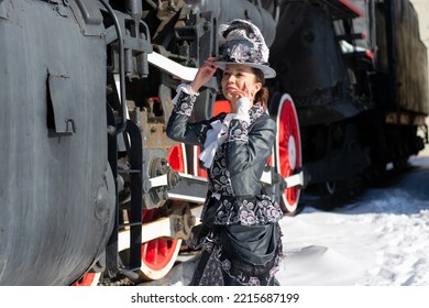 Girl Dressed As A Noblewoman Of The 19th Century Near A Steam Locomotive