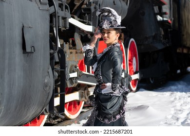 Girl Dressed As A Noblewoman Of The 19th Century Near A Steam Locomotive