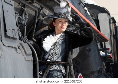 Girl Dressed As A Noblewoman Of The 19th Century Near A Steam Locomotive