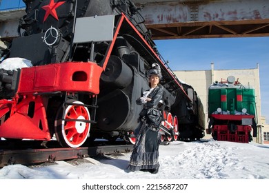 Girl Dressed As A Noblewoman Of The 19th Century Near A Steam Locomotive