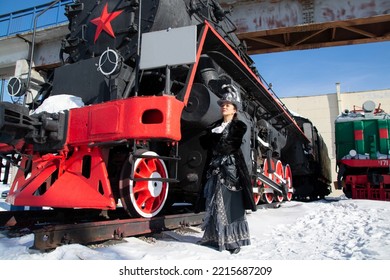 Girl Dressed As A Noblewoman Of The 19th Century Near A Steam Locomotive