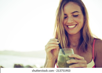 Girl Drinking A Cocktail At Sunset