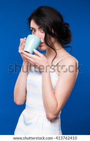 girl is drinking from a cup on a blue background