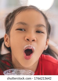 Girl Is Drinking A Glass Of Milk With Milk Foam All Over Her Mouth, For Kid Healthy Eating Concept.