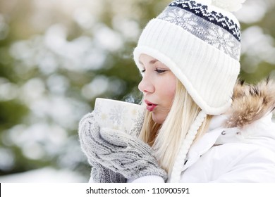 Girl drinking hot tea in the winter forest, close up, horizontal format - Powered by Shutterstock