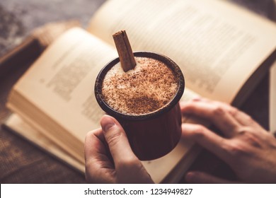 Girl drinking salep (milky traditional hot drink) while reading book