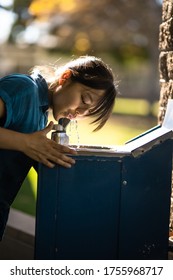 Girl Drinking Water At Fountain Outdoors