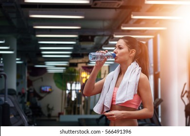 Girl Drinking Water In Gym After Workout. Lens Flare