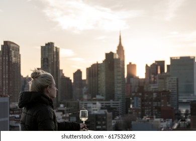 Girl drinking wine in New York City at sunset - rooftop bar