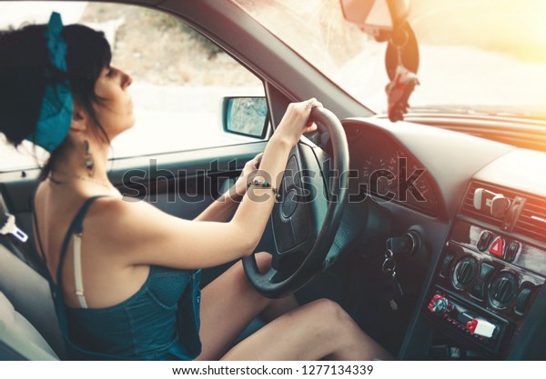 Girl driving a car in\
sunlight