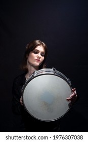 Girl With Drum Portrait Of A Smiling Young Beautiful Drummer Girl, In Black, Holding A Snare Drum, Posing. On A Black Background