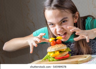 girl eagerly pounced on a hamburger, holding out her arms to him with a crooked fingers - Powered by Shutterstock