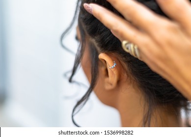 Girl With Ear Piercing And Beautician Hand