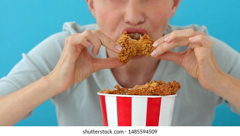 Girl Eating Chicken Wings, High Calorie Food And Health Risks, Cholesterol Blue Background