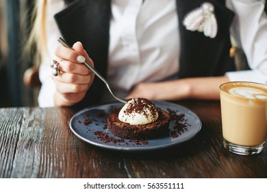 Girl eating chocolate dessert brown with white cream