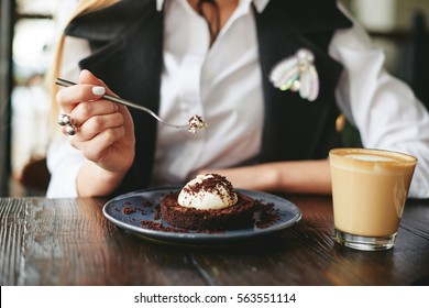 Girl eating chocolate dessert brown with white cream