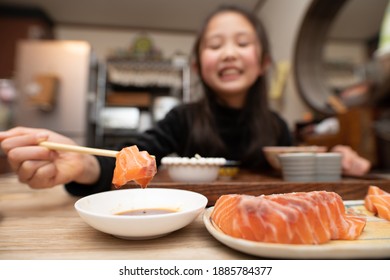 Girl Eating Sashimi With Chopsticks