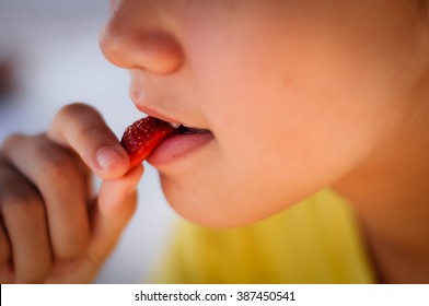 Girl eating strawberry.