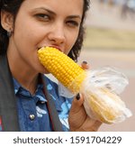The girl eats boiled corn.