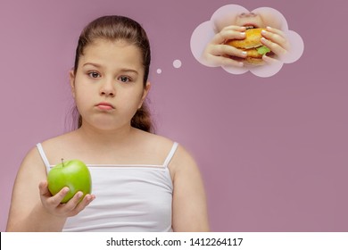the girl eats a green Apple, but dreams about hamburger. Harmoni