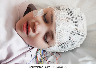 Girl With EEG Electrodes Attached To Her Head For Medical Test