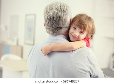 Girl Embracing Grand Father At Home